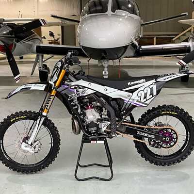 DeCal Works Custom Dirt Bike with white and black graphics, a purple accent and 2 wheel house Logos