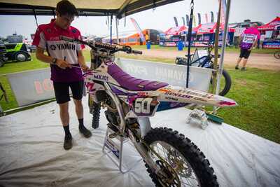 Purple and white throw back yamaha complete dirt bike graphics mechanic working on #50 Austin Jones MX bike